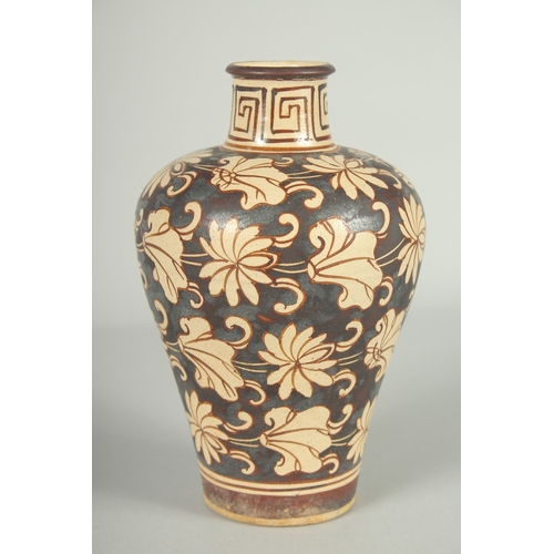 63 - A CHINESE JIZHOU KILN POTTERY VASE, with lilipad and flower head decoration, 19cm high.