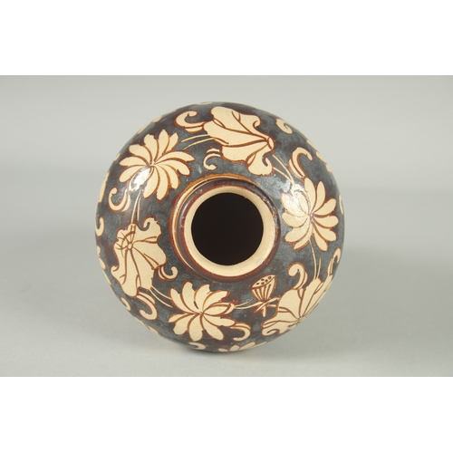 63 - A CHINESE JIZHOU KILN POTTERY VASE, with lilipad and flower head decoration, 19cm high.