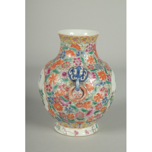 69 - A SMALL CHINESE FAMILLE ROSE PORCELAIN TWIN HANDLE VASE, painted with flora, the base with character... 