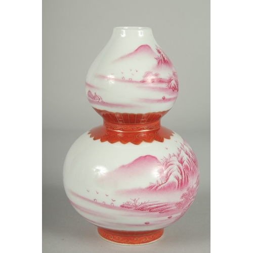 70 - A CHINESE PINK AND WHITE PORCELAIN DOUBLE GOURD VASE, painted with sweeping landscape scenes, the ba... 