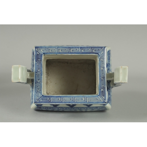 73 - A CHINESE BLUE AND WHITE PORCELAIN TWIN HANDLE CENSER, raised on four square-form feet, 19.5cm high.