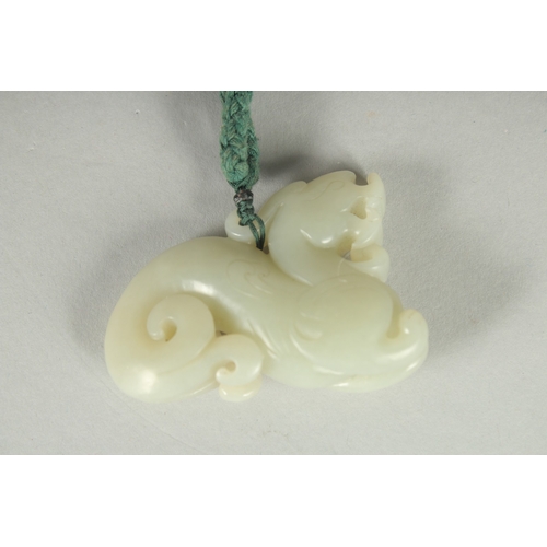 76 - AN EARLY 20TH CENTURY CHINESE CARVED JADE PENDANT OF A LION DOG, 6cm wide.