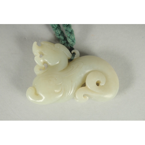 76 - AN EARLY 20TH CENTURY CHINESE CARVED JADE PENDANT OF A LION DOG, 6cm wide.