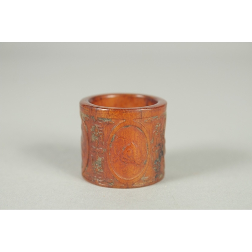 78 - A CHINESE CARVED AND STAINED BONE THUMB RING.