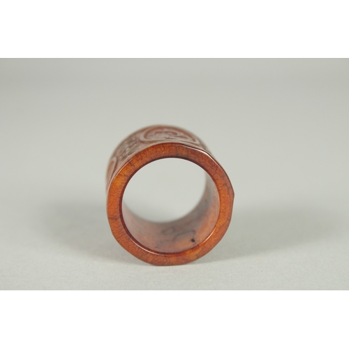 78 - A CHINESE CARVED AND STAINED BONE THUMB RING.