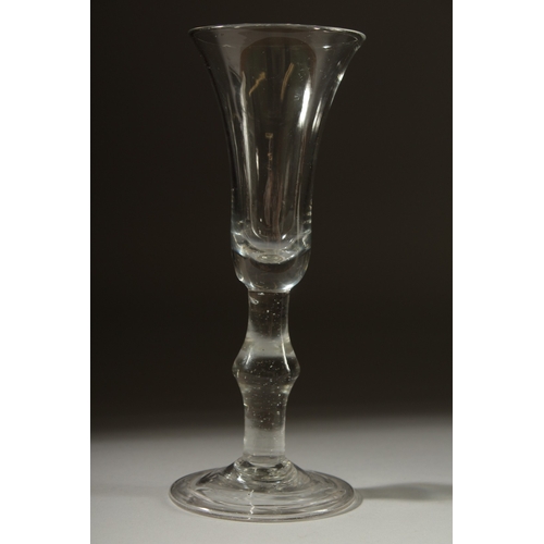 1039 - A GEORGIAN GLASS with long tapering plain bowl, knop to the stem. 7ins high.