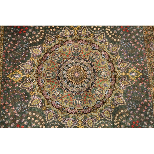 1001 - A GOOD PERSIAN SILK CARPET rich green ground with central circular floral medallion decoration all o... 