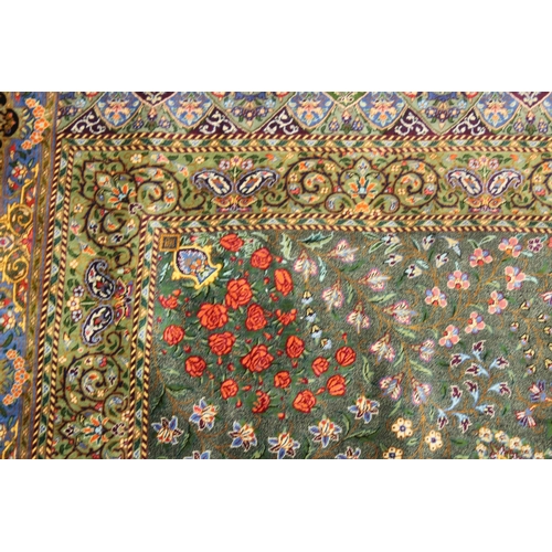 1001 - A GOOD PERSIAN SILK CARPET rich green ground with central circular floral medallion decoration all o... 