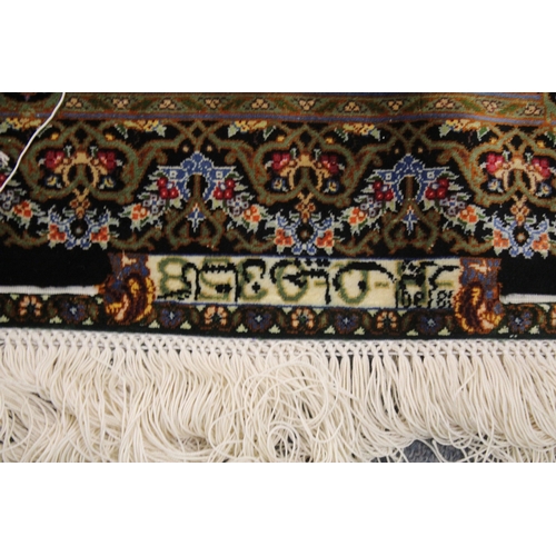 1001 - A GOOD PERSIAN SILK CARPET rich green ground with central circular floral medallion decoration all o... 