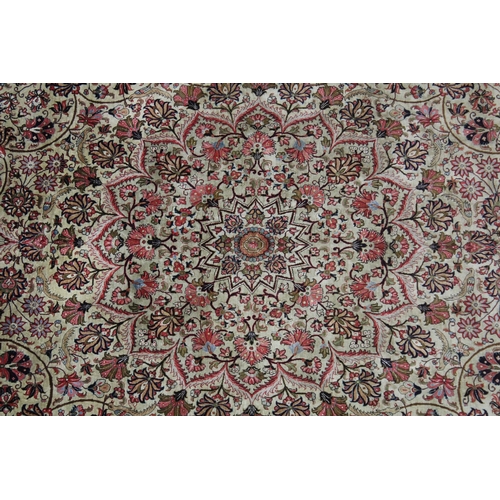 1009 - A GOOD LARGE PERSIAN SILK CARPET cream ground within a red ground border, decorated with floral and ... 