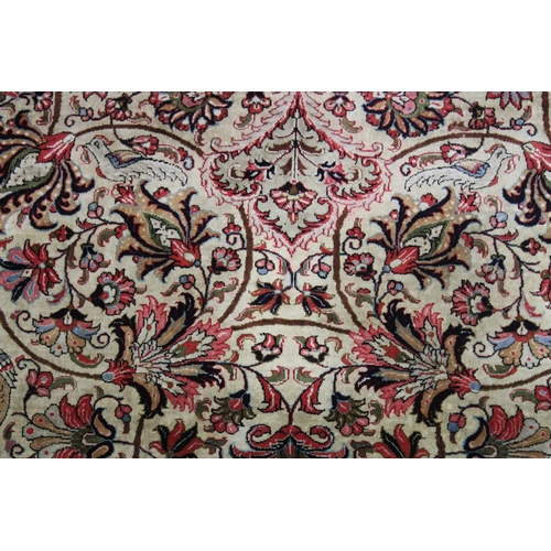 1009 - A GOOD LARGE PERSIAN SILK CARPET cream ground within a red ground border, decorated with floral and ... 