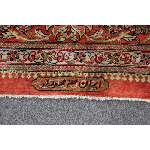 1009 - A GOOD LARGE PERSIAN SILK CARPET cream ground within a red ground border, decorated with floral and ... 