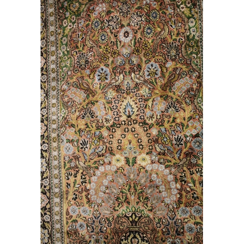 1010 - A PERSIAN PART SILK RUG salmon ground decorated with a vase of flowers and birds. 5ft 5ins x 3ft 2in... 