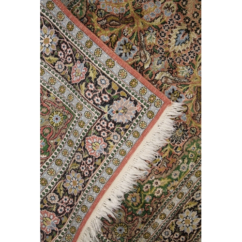 1010 - A PERSIAN PART SILK RUG salmon ground decorated with a vase of flowers and birds. 5ft 5ins x 3ft 2in... 