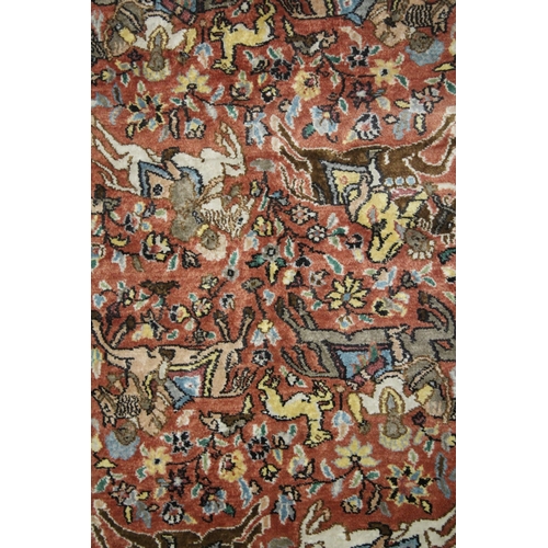 1012 - A SMALL PART SILK PERSIAN HUNTING RUG rust ground decorated with huntsmen on horseback. 3ft 3ins x 2... 