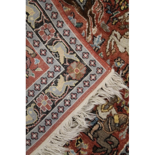 1012 - A SMALL PART SILK PERSIAN HUNTING RUG rust ground decorated with huntsmen on horseback. 3ft 3ins x 2... 