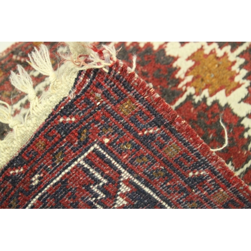 1015 - A SMALL PERSIAN MAT red ground with a geometric design. 2ft x 1ft 4ins.