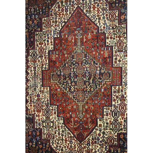 1017 - A PERSIAN WOOL CARPET cream, red and blue ground with all over stylised decoration. 4ft 9ins x 4ft 1... 