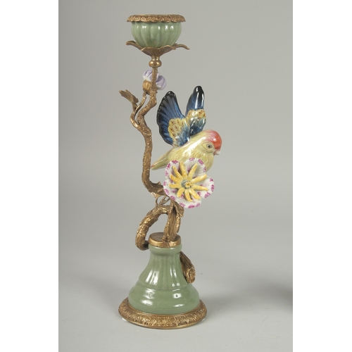 1090 - A GOOD PAIR OF PORCELAIN AND GILDED METAL BIRD CANDLESTICKS on circular bases.  13ins high.