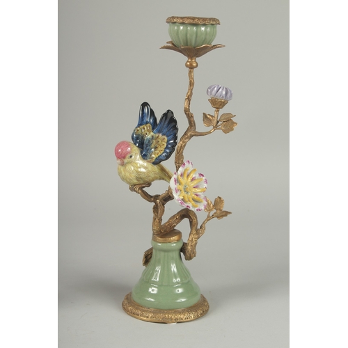 1090 - A GOOD PAIR OF PORCELAIN AND GILDED METAL BIRD CANDLESTICKS on circular bases.  13ins high.