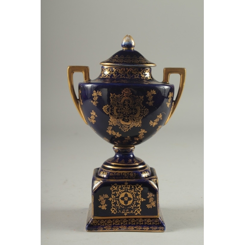 1091 - A SMALL VIENNA RICH BLUE GROUND TWO HANDLED URN AND COVER with a panel of a young lady with a cupid.... 