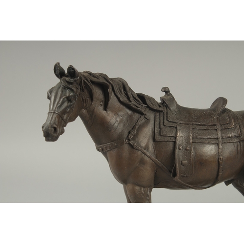 1105 - A BRONZE OF A HORSE with saddle.  9ins long on a shaped base.