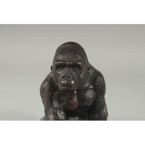 1110 - A BRONZE GORILLA on a metal base.  6ins high.