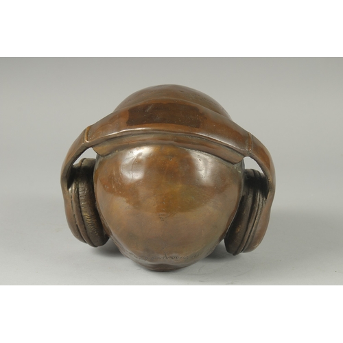 1116 - A BRONZE SKULL with headphones. 6ins high.