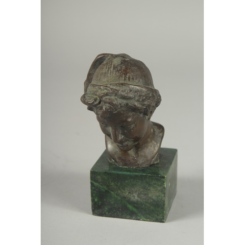 1120 - A SMALL BRONZE BUST OF A YOUNG MAN.  Signed, 4ins high on a marble base.