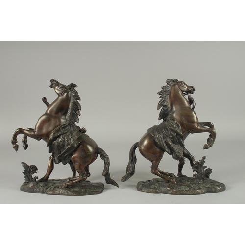 1126 - AFTER COUSTOU. A PAIR OF BRONZE MARLEY HORSES AND ATTANDANTS. Signed.