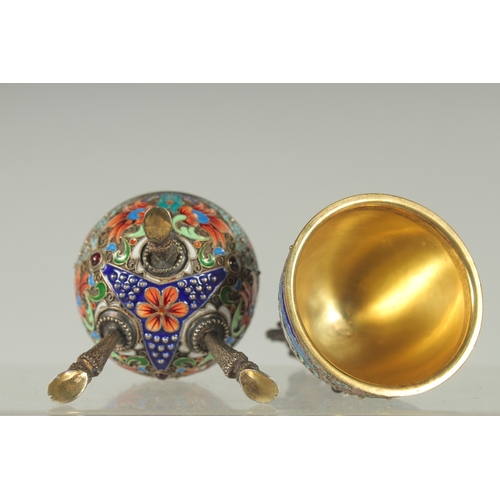 1423 - A LARGE RUSSIAN SILVER AND ENAMEL EGG on three curving feet. 12cm long 5cm diameter decorated with t... 