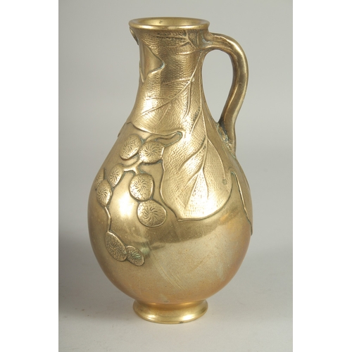 10 - A JAPANESE BRASS JUG, with relief foliate decoration, 23cm high.