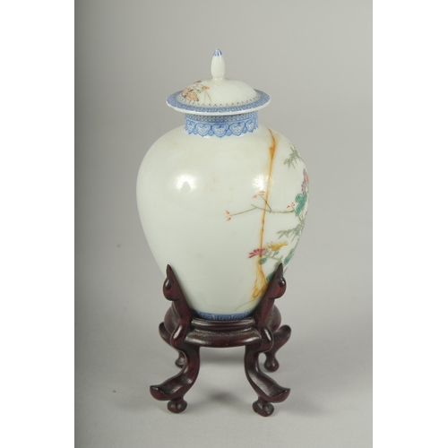 11 - A SMALL CHINESE REPUBLIC PERIOD PORCELAIN JAR AND COVER, on a fitted wooden stand, painted with bird... 