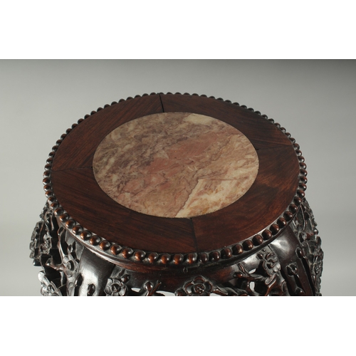 143 - A CHINESE MARBLE INSET CARVED HARDWOOD VASE STAND, with carved and pierced floral frieze on curving ... 