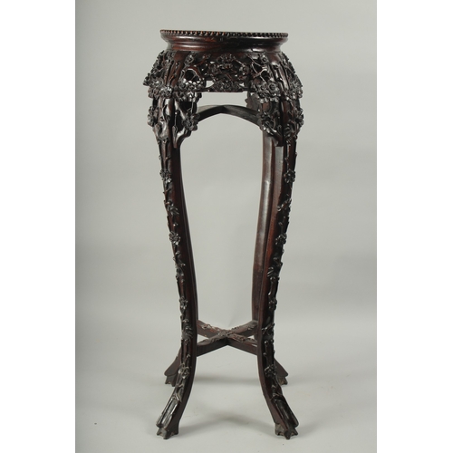 143 - A CHINESE MARBLE INSET CARVED HARDWOOD VASE STAND, with carved and pierced floral frieze on curving ... 