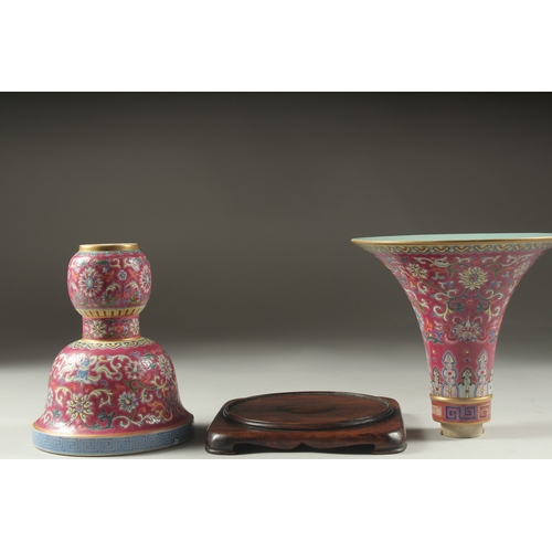 149 - A CHINESE PINK GROUND FAMILLE ROSE PORCELAIN SECTIONAL GU VASE, and fitted hardwood stand, bearing Q... 