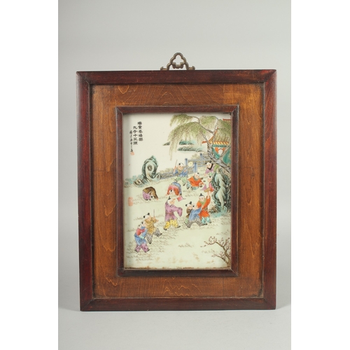 15 - A CHINESE REPUBLIC FAMILLE ROSE PORCELAIN PLAQUE, inset within a hardwood frame, panel depicting an ... 