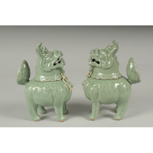 20 - A PAIR OF CHINESE CELADON GLAZED PORCELAIN FIGURAL CENSER BURNERS, in the form of mythical beasts wi... 