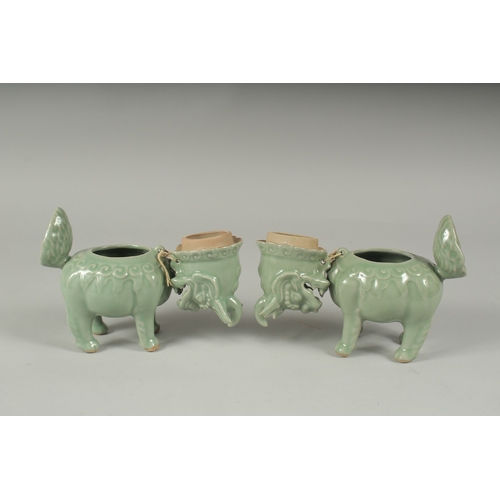 20 - A PAIR OF CHINESE CELADON GLAZED PORCELAIN FIGURAL CENSER BURNERS, in the form of mythical beasts wi... 