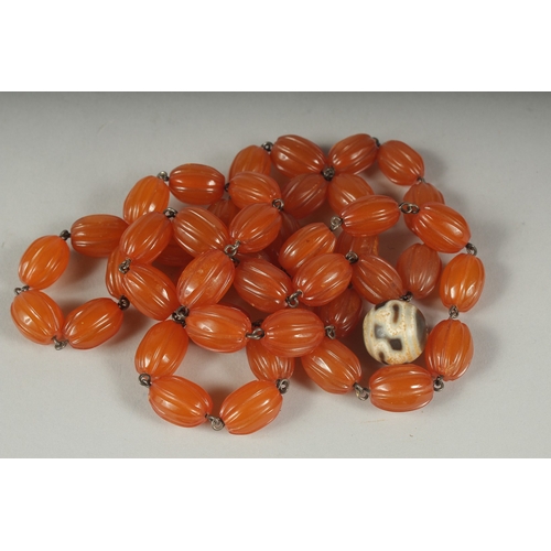 43 - AN EARLY 20TH CENTURY AMBER BEADED NECKLACE AND DZI BEAD, (2).