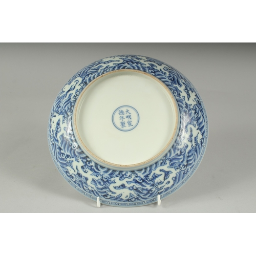 45A - A CHINESE BLUE AND WHITE PORCELAIN DRAGON PLATE, with incised white dragon on stylised waves, six-ch... 