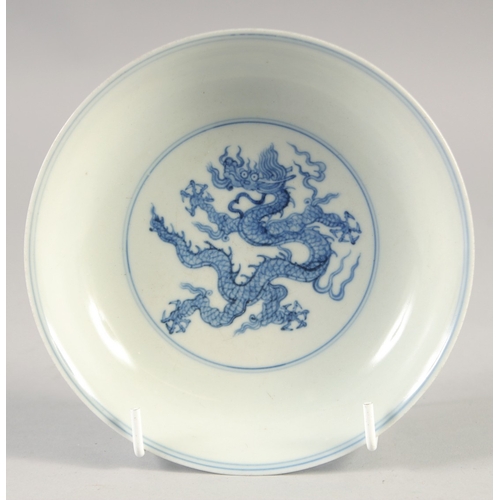 49 - A CHINESE BLUE AND WHITE PORCELAIN DISH, decorated with dragons, bearing six-character mark, 15cm di... 