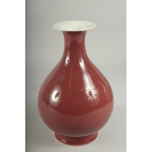 493 - A CHINESE RED GLAZED PORCELAIN VASE, character mark to base, 23cm high.