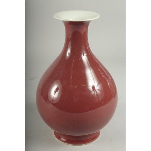 493 - A CHINESE RED GLAZED PORCELAIN VASE, character mark to base, 23cm high.