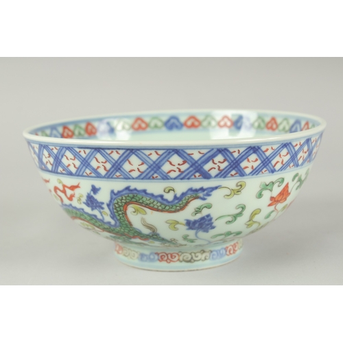 55 - A CHINESE WUCAI PORCELAIN BOWL, painted with dragons and flora, 20.5cm diameter.