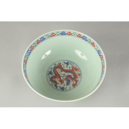 55 - A CHINESE WUCAI PORCELAIN BOWL, painted with dragons and flora, 20.5cm diameter.