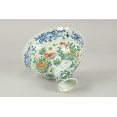 56 - A CHINESE WUCAI PORCELAIN STEM CUP, painted with ducks and aquatic flora, bowl 17cm diameter.