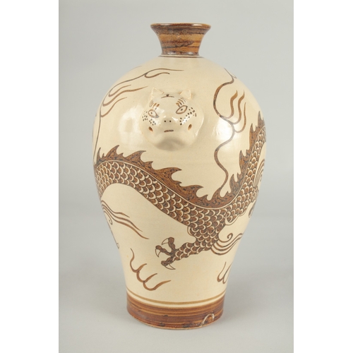 64 - A CHINESE CIZHOU DRAGON VASE, with moulded twin handles, 29.5cm high.