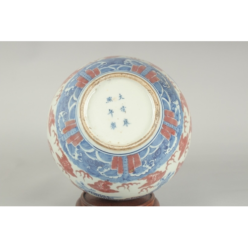 66 - A CHINESE UNDERGLAZE RED AND BLUE PORCELAIN DRAGON VASE ON HARDWOOD STAND, painted with three dragon... 