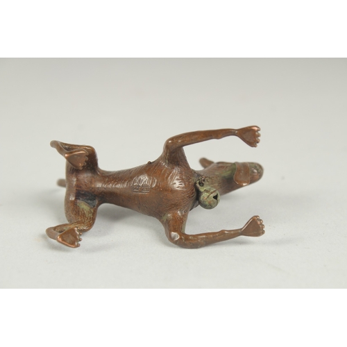 77 - A JAPANESE BRONZE OKIMONO OF A DOG, with hanging bell on the collar, mark to underside, 6.5cm long.